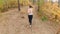 Slow motion footage from high point of beautiful blonde woman jogging at autumn forest