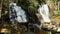 slow motion footage of the rushing waters of Smith Creek and waterfall at Anna Ruby Falls with rocks and lush green trees