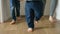 Slow motion footage shows two young boys and mother playing football on a wooden floor in a house corridor