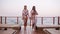 Slow motion footage of two attractive girls walking sensually in summer stylish clothes in same colors. Seaside area