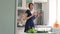 Slow motion of funny woman cook dance with green lettuce while cooking in kitchen at home