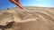 Slow motion. Girl picks up handful of sand in her palm and sprinkles