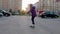 Slow motion girl skateboarding on city street while evening sunset. Teenager girl riding skateboard on sunny street in