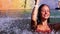 Slow motion of girl under water fountain in swimming pool