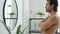 Slow motion of good-looking young man posing watching mirror reflection in bathroom