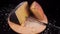 Slow motion of grated pecorino cheese falling on a slice of Sardinian pecorino cheese on a wooden cutting board