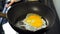 Slow-motion of hand cracking egg dropping into a pan