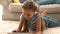 In slow motion happy girl using digital tablet on rug with mother reading book in background