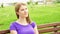 Slow Motion Happy Smiling Young Woman Enjoying Nature. Sitting on bench in green park. Freedom loneliness concept