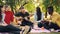 Slow motion of happy students playing the guitar and enjoying music in park on picnic in autumn, guitarist is playing