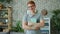 Slow motion of happy teenager in glasses holding book laughing at home