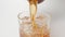 SLOW MOTION: Human pours a whiskey in a glass with an ice cubes from a bottle - close up