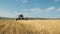 Slow motion image of combine harvester driving through field collecting grain. Agricultural machinery rides towards