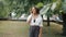 Slow motion of joyful mixed race woman talking on mobile phone outdoors in park
