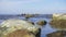 Slow motion large stones in calm water on the horizon gulls and ships