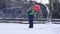 Slow motion of a little boy throwing snow with a snow shovel