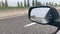 Slow motion - looking at the reflection in the car rear mirror while driving