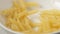 SLOW MOTION: Macaroni fall on white dish close up
