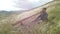 Slow motion the maestro plays the Australian Aboriginal wind instrument Didgeridoo against the backdrop of feather grass