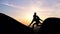 Slow motion of a man gives a hand to a woman helping her down a cliff face.