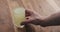 Slow motion man hand take glass with vitamin drink from wood table