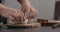 Slow motion man makes sandwich with avocado and cream cheese on olive board