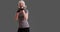 Slow motion of mature woman shadowboxing on solid gray background with copyspace