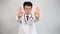 Slow motion. A middle-aged Asian doctor raises his hand and expresses his disapproval.