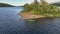 Slow motion panning video on women in green kayak stopped beside small island, lake in Scandinavian mountains. Sweden, Norway