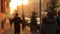 Slow motion. People walking on the background golden sunset in the city. Defocused video