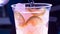 Slow motion pink drink beautifully pour into a glass with ice and lime slices