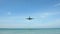 Slow motion of a plane approaching for landing and passing just above the camera at the beach