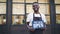Slow motion portrait of African American guy urban cafe owner posing with we are open sign standing outdoors and looking