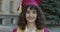 Slow motion portrait of ambitious lady in graduation hat standing outdoors smiling enjoying master degree