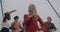 Slow motion portrait of beautiful Caucasian lady with blond hair dancing at rooftop party with friends