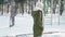 Slow motion portrait of beautiful happy smiing young woman in warm winter clothes walking in snowy winter park at frozzy