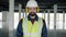 Slow motion portrait of builder wearing safety clothing and headphones standing in commercial building