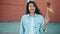 Slow motion portrait of cheerful Asian woman holding German flag outdoors