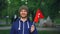 Slow motion portrait of cheerful guy world traveller in casual clothes holding Swiss flag, looking at camera with glad