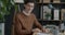 Slow motion portrait of cheerful office worker sitting at desk smiling looking at camera