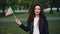 Slow motion portrait of cheerful sports fan pretty young woman waving Portuguese flag, looking at camera and laughing