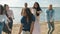 Slow motion portrait of crazy people students dancing outdoors on beach laughing having fun