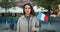 Slow motion portrait of cute French girl standing outdoors with flag of France