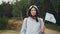 Slow motion portrait of female world traveller holding Argentinian flag flying in the wind, smiling and looking at