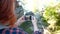 Slow motion portrait of girl traveller with knapsack taking pictures of beautiful view from cliff using smartphone.