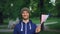 Slow motion portrait of handsome Frenchman waving official flag looking at camera and smiling with beautiful park in