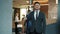 Slow motion portrait of handsome middle-aged businessman in suit standing in hotel lobby