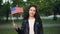 Slow motion portrait of happy American tourist waving flag of the United States, looking at camera and smiling. World