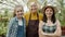 Slow motion portrait of happy family farmers smiling and laughing in greenhouse