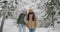 Slow motion portrait of happy young man and woman standing in winter woods enjoying journey